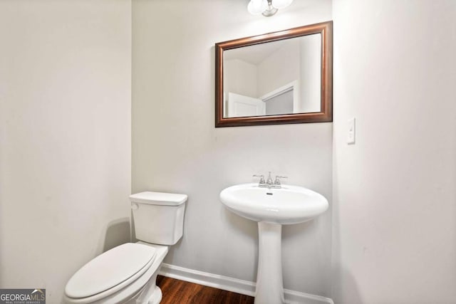 bathroom with hardwood / wood-style flooring, toilet, and sink