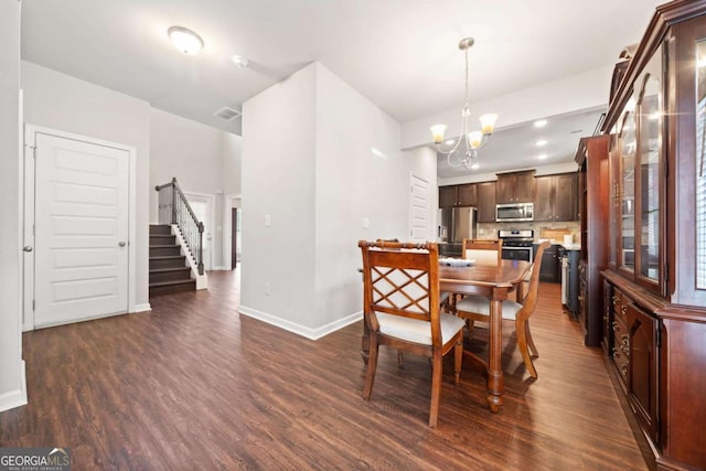 dining space featuring dark hardwood / wood-style flooring and an inviting chandelier