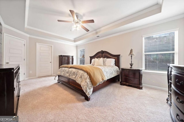 bedroom featuring a raised ceiling, ceiling fan, and light colored carpet