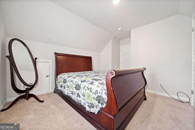 bedroom featuring light colored carpet and lofted ceiling