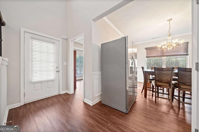 interior space featuring dark hardwood / wood-style floors, an inviting chandelier, and crown molding