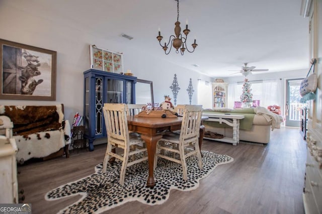 dining area with ceiling fan with notable chandelier and hardwood / wood-style flooring