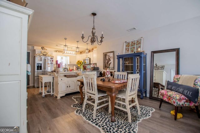 dining area with dark wood-type flooring and a chandelier