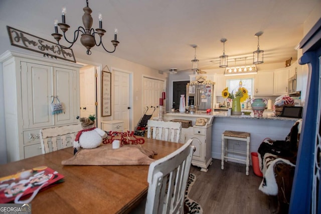 dining space featuring dark hardwood / wood-style flooring and an inviting chandelier