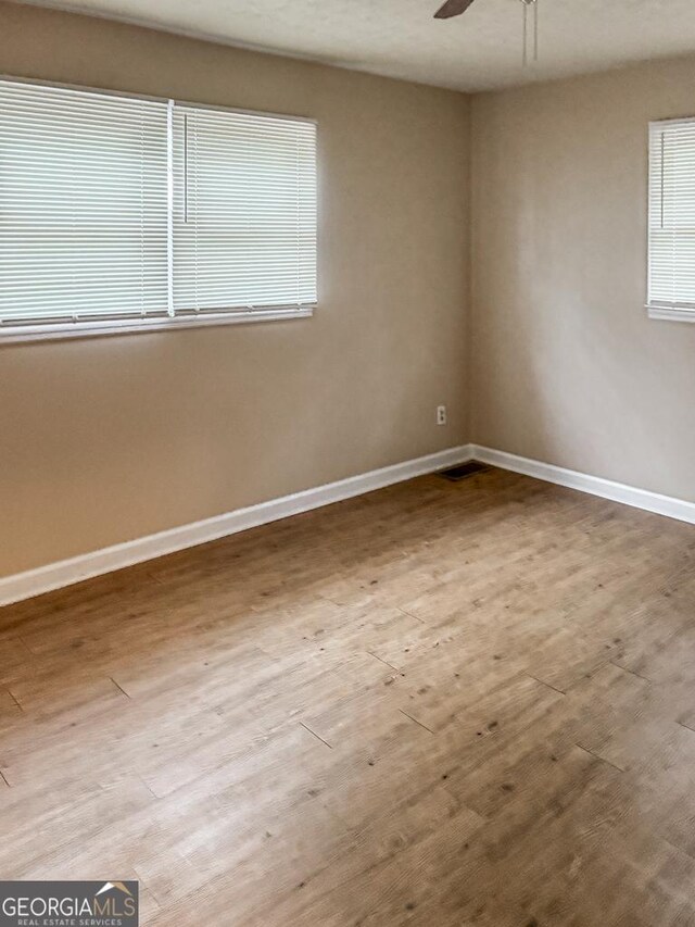 empty room with ceiling fan and hardwood / wood-style floors