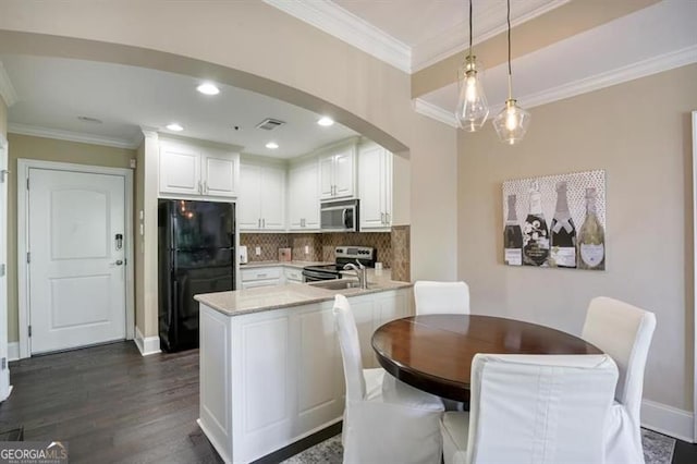 kitchen featuring arched walkways, crown molding, stainless steel appliances, visible vents, and white cabinets