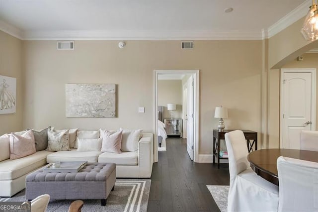 living room with ornamental molding, dark wood-style flooring, visible vents, and baseboards