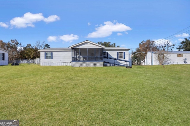 rear view of house featuring a yard and a sunroom