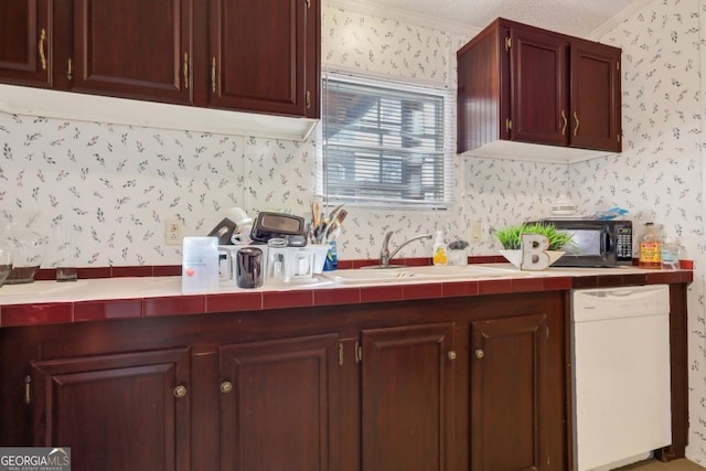 kitchen with tile countertops, white dishwasher, sink, ornamental molding, and a textured ceiling