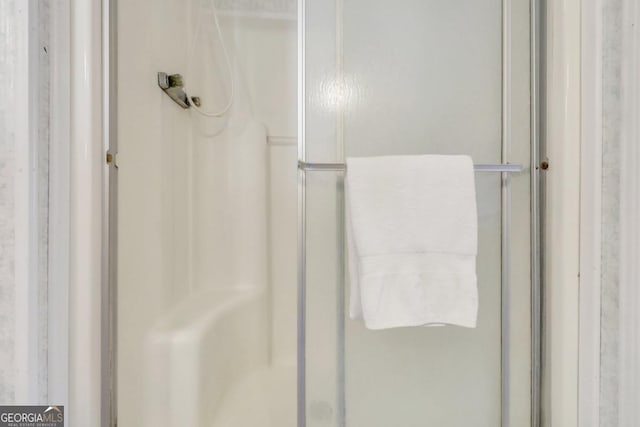 bathroom featuring a shower with door