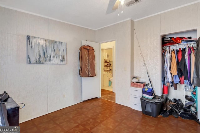 bedroom featuring ceiling fan, parquet flooring, ornamental molding, and a closet