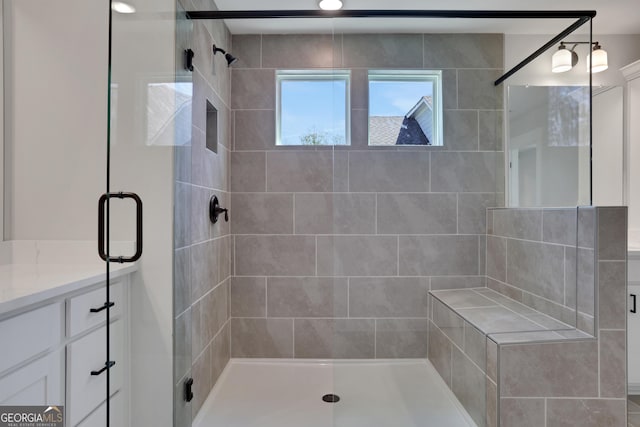 bathroom with a shower stall and vanity