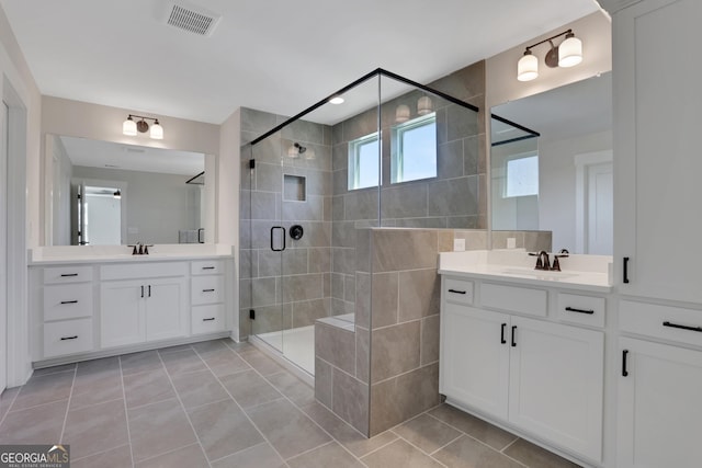 bathroom with visible vents, a sink, two vanities, and a shower stall