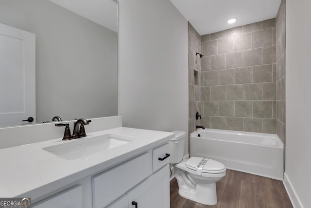 bathroom with vanity, wood finished floors, toilet, baseboards, and  shower combination
