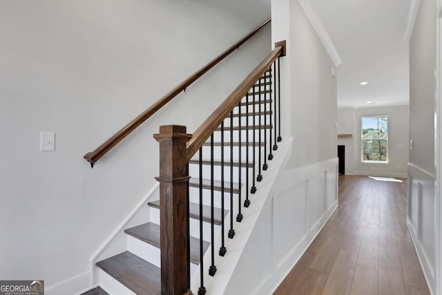 stairway with wood-type flooring and recessed lighting
