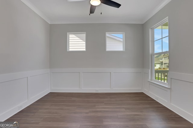 empty room with crown molding, ceiling fan, a wainscoted wall, and a decorative wall