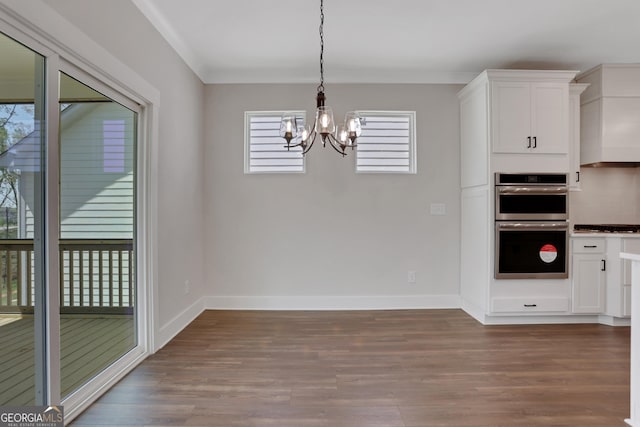 kitchen featuring double oven, white cabinetry, wood finished floors, and a chandelier