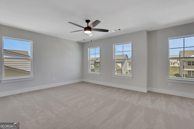 empty room with carpet flooring, baseboards, and a wealth of natural light