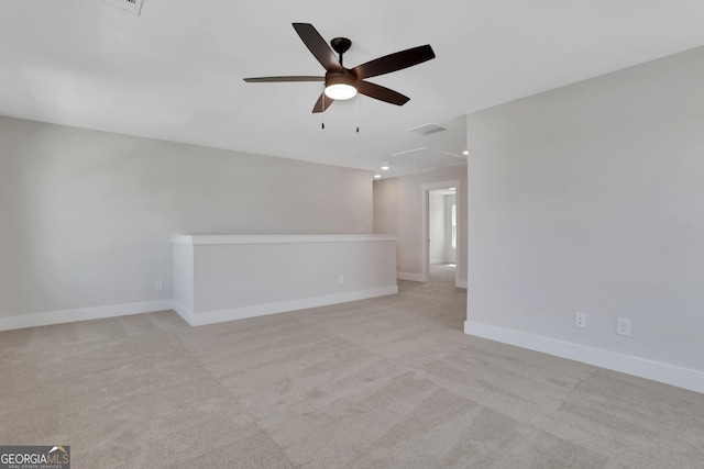 empty room with light colored carpet, ceiling fan, visible vents, and baseboards