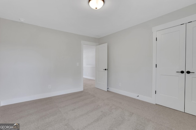 unfurnished bedroom with carpet flooring, baseboards, and a closet