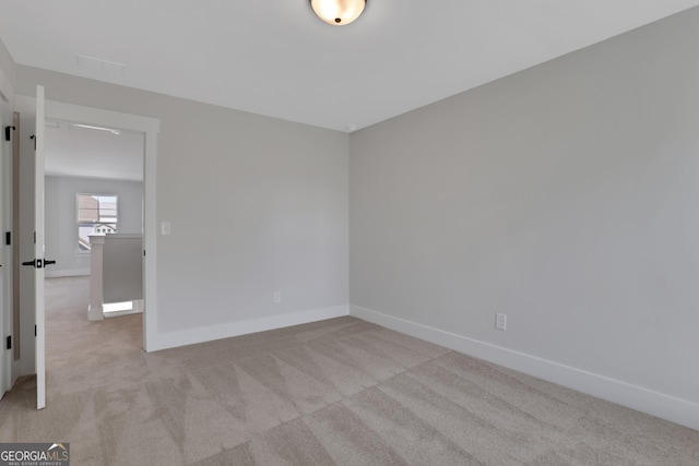 unfurnished room featuring carpet floors and baseboards