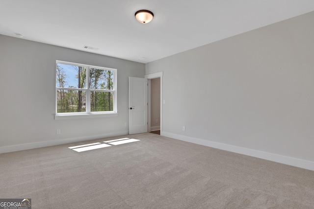 unfurnished room featuring carpet floors, baseboards, and visible vents