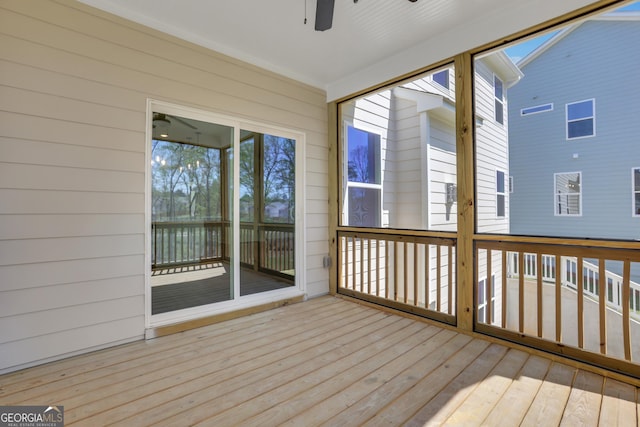 unfurnished sunroom featuring wood-type flooring, wood walls, and a wooden deck