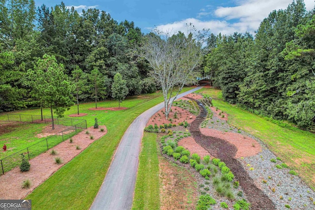surrounding community with fence and a yard