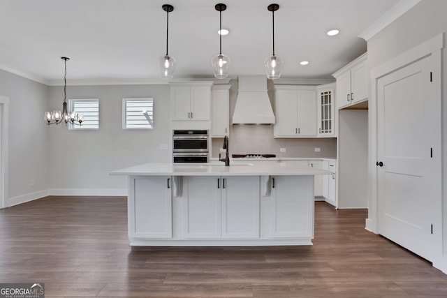 kitchen with light countertops, premium range hood, crown molding, and baseboards