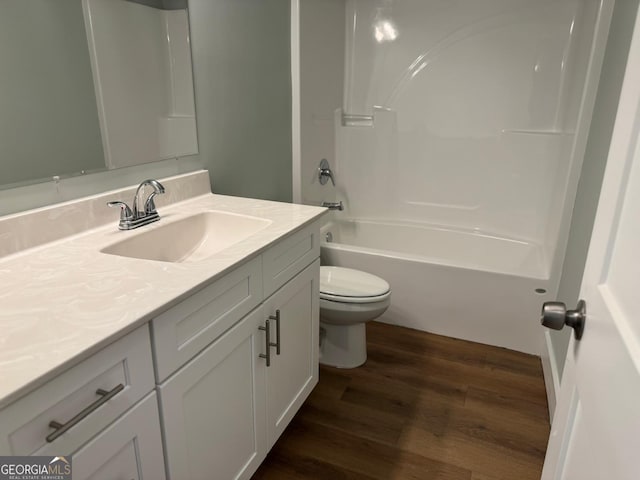 full bathroom with bathtub / shower combination, wood-type flooring, vanity, and toilet