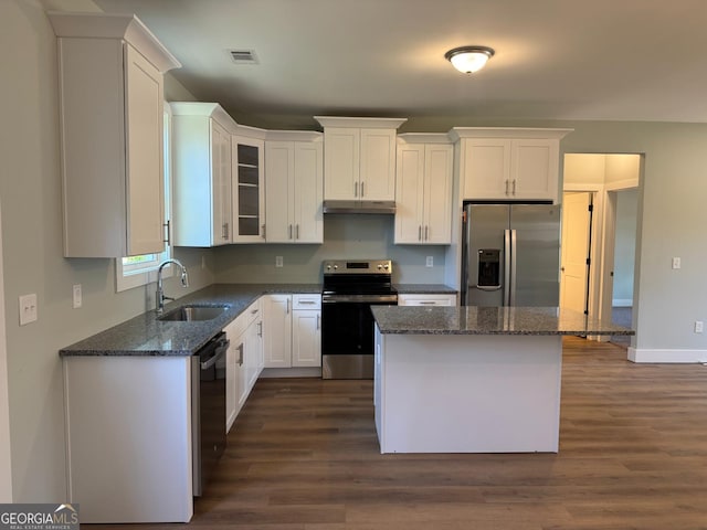 kitchen with dark hardwood / wood-style flooring, stainless steel appliances, sink, a center island, and white cabinetry