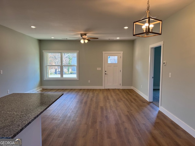 interior space with dark hardwood / wood-style flooring and ceiling fan with notable chandelier