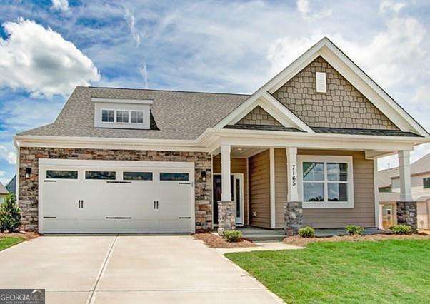 craftsman inspired home with a porch, a garage, and a front lawn