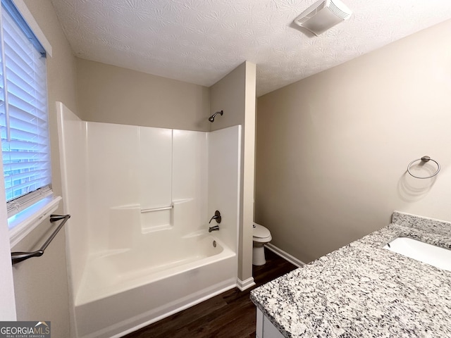 full bathroom featuring shower / bath combination, vanity, a textured ceiling, hardwood / wood-style floors, and toilet