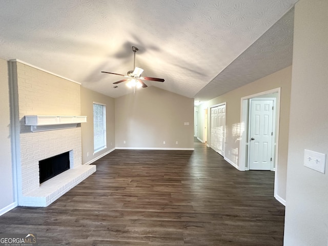 unfurnished living room with a textured ceiling, ceiling fan, a fireplace, dark hardwood / wood-style floors, and lofted ceiling