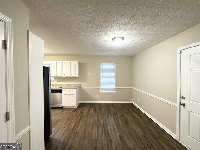 kitchen featuring white cabinets, stainless steel dishwasher, dark wood-type flooring, and a textured ceiling