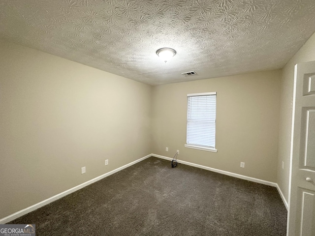 spare room featuring carpet floors and a textured ceiling