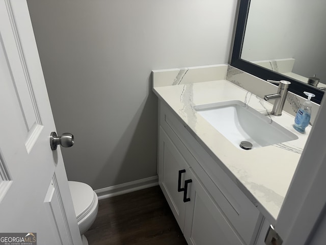 bathroom with vanity, toilet, and wood-type flooring