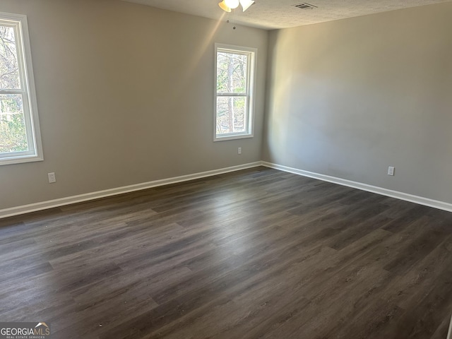 unfurnished room with a textured ceiling, ceiling fan, and dark hardwood / wood-style floors