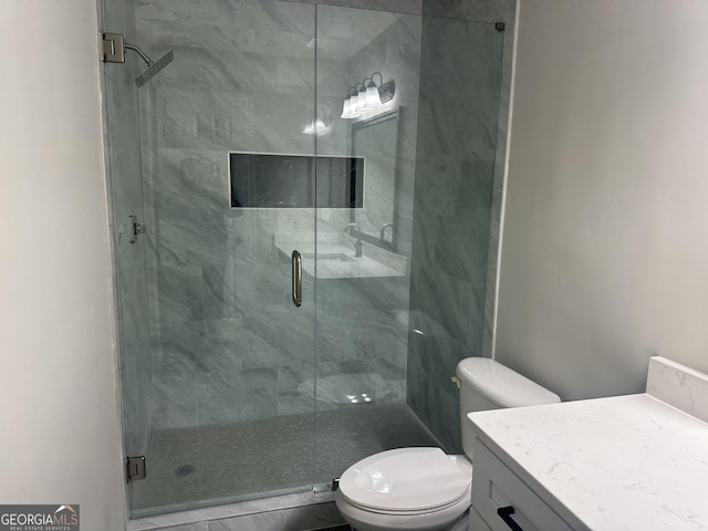 bathroom with vanity, toilet, and a shower with door