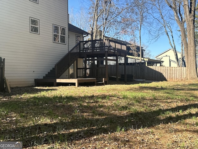 rear view of house featuring a lawn and a deck