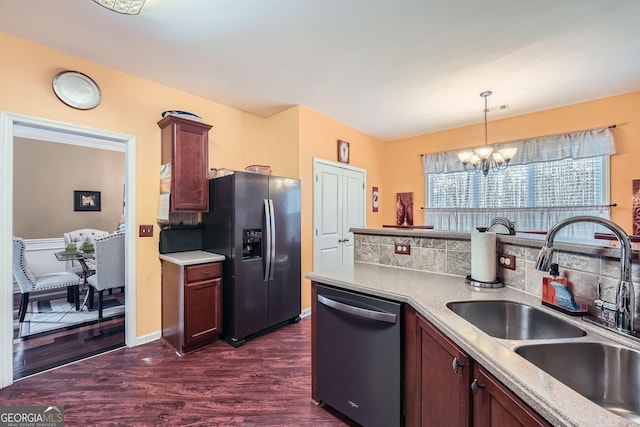 kitchen featuring dark wood-type flooring, sink, hanging light fixtures, appliances with stainless steel finishes, and a chandelier