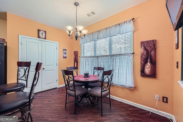 dining room with dark hardwood / wood-style flooring and a notable chandelier