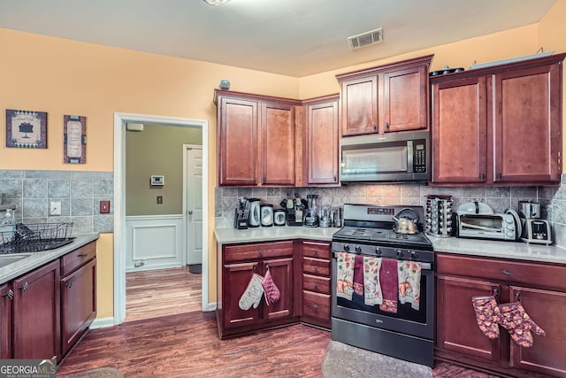 kitchen featuring tasteful backsplash, stainless steel electric stove, and dark wood-type flooring