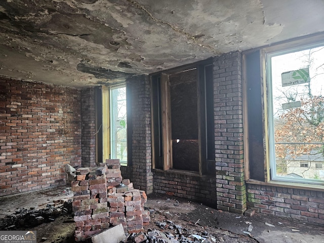 misc room featuring plenty of natural light and brick wall