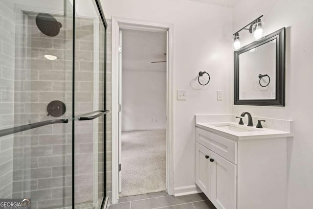 bathroom featuring tile patterned flooring, vanity, and a shower with door