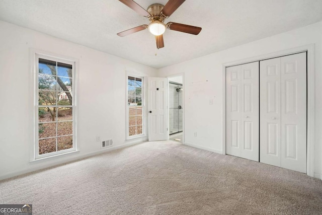 unfurnished bedroom featuring carpet, ceiling fan, and a closet