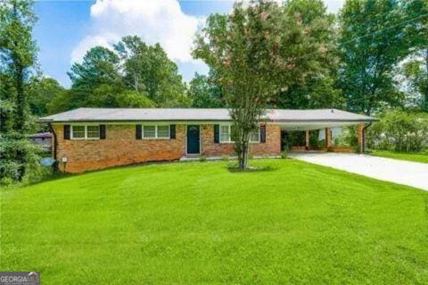 ranch-style home with a front yard and a carport