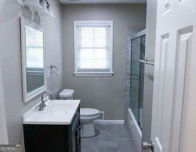 full bathroom featuring vanity, toilet, plenty of natural light, and bath / shower combo with glass door