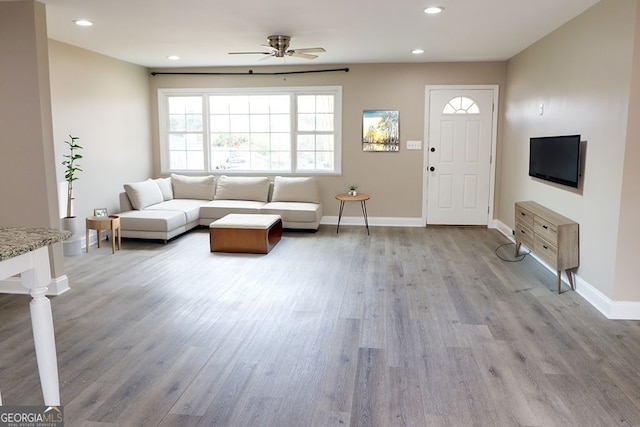 living room with light hardwood / wood-style floors and ceiling fan